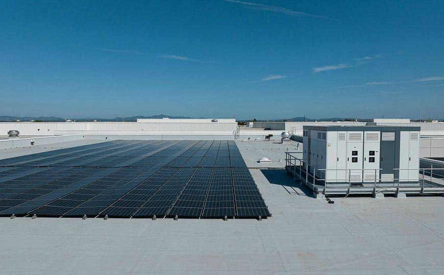 Rooftop solar array with battery containers